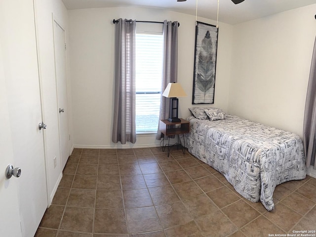 tiled bedroom featuring ceiling fan