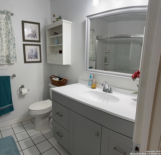 bathroom featuring tile patterned flooring, walk in shower, vanity, and toilet