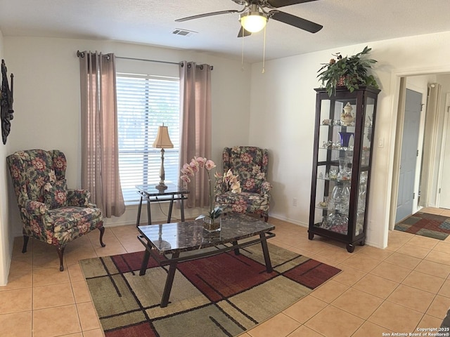 sitting room with light tile patterned flooring, ceiling fan, and a textured ceiling