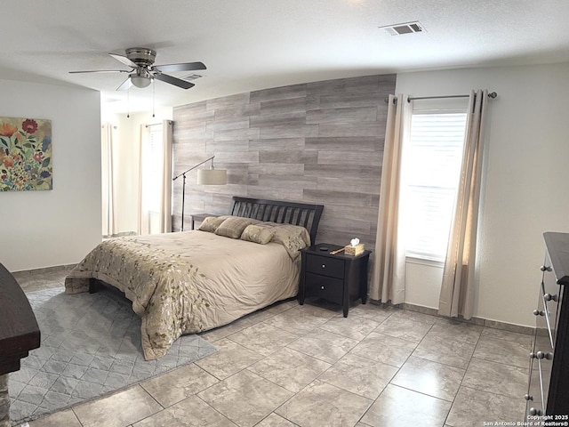 bedroom with ceiling fan and a textured ceiling