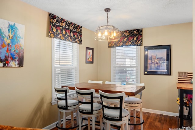 dining room featuring plenty of natural light, dark wood-type flooring, and a textured ceiling