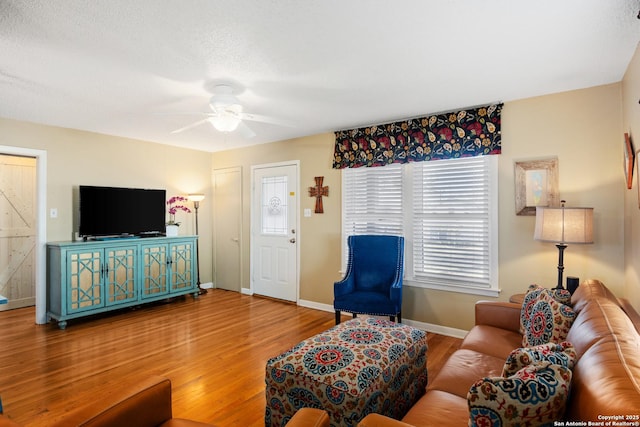 living room featuring ceiling fan, hardwood / wood-style floors, and a textured ceiling