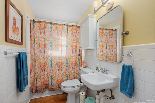 bathroom with a shower with shower curtain, toilet, sink, and tile walls