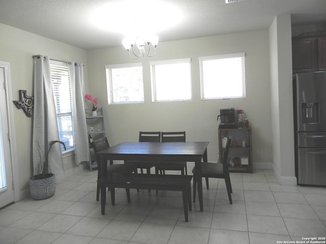 tiled dining space with a chandelier