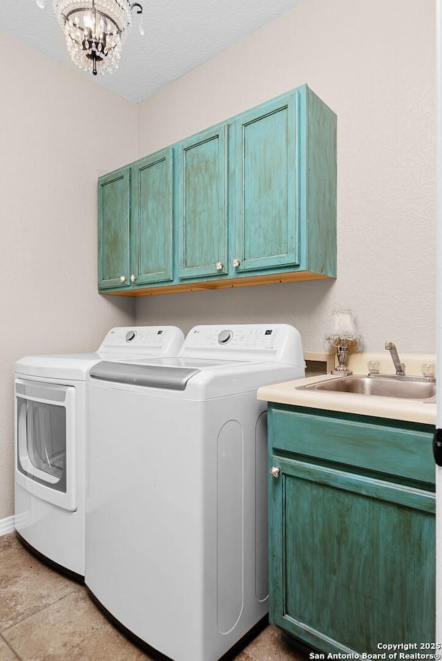 washroom with sink, cabinets, separate washer and dryer, a textured ceiling, and a notable chandelier