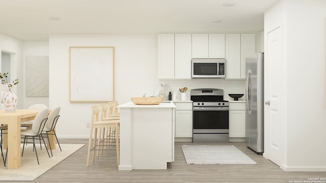 kitchen featuring stainless steel appliances, kitchen peninsula, white cabinets, and light wood-type flooring