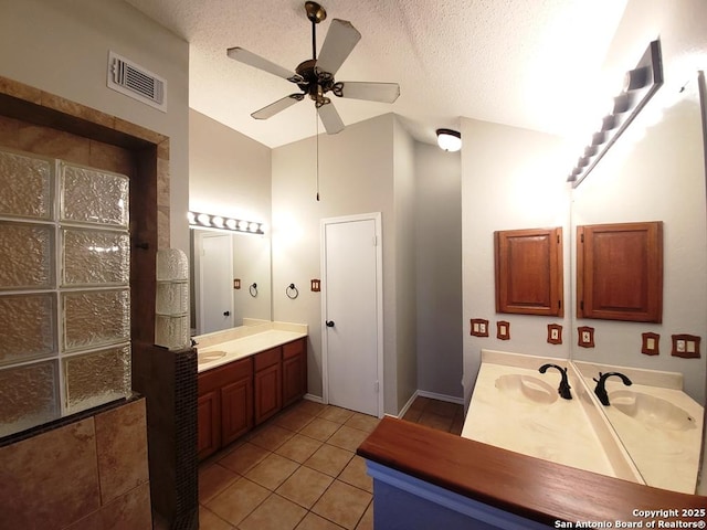 bathroom featuring tile patterned floors, lofted ceiling, a textured ceiling, vanity, and ceiling fan