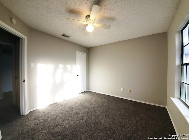 carpeted empty room with ceiling fan and a textured ceiling