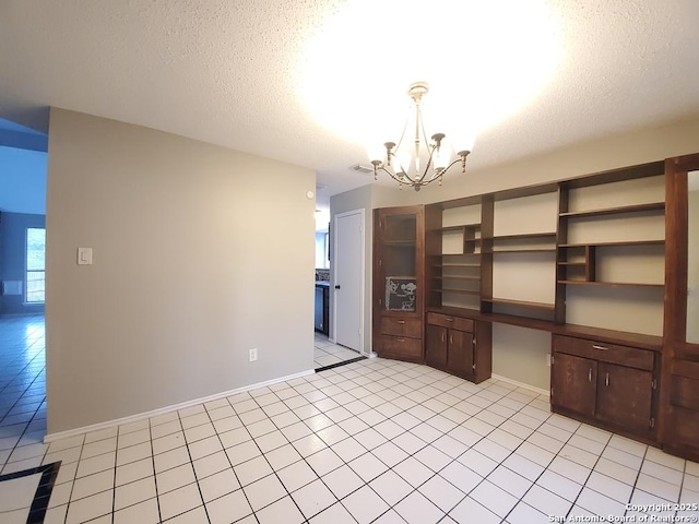 interior space with light tile patterned flooring, built in desk, and a notable chandelier