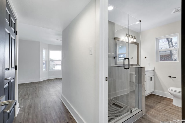 bathroom featuring vanity, toilet, hardwood / wood-style floors, and walk in shower