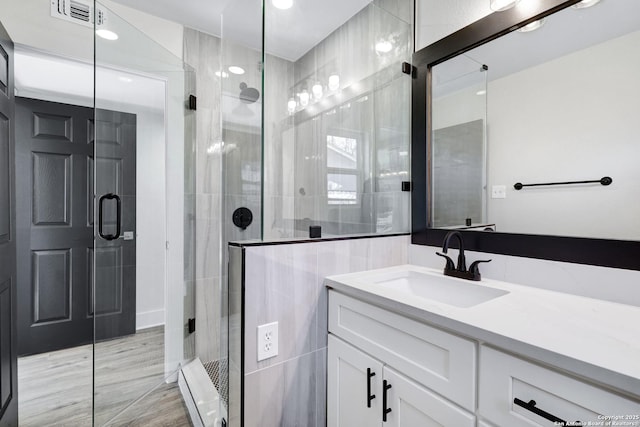 bathroom with vanity and a shower with shower door