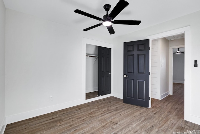 unfurnished bedroom featuring hardwood / wood-style floors, ceiling fan, and a closet