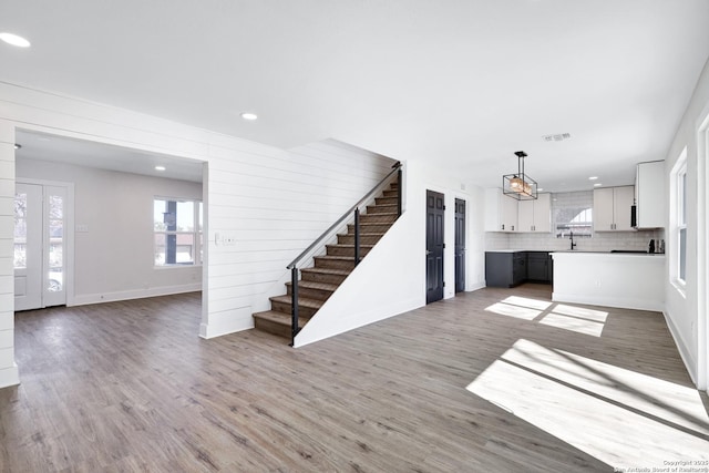 unfurnished living room featuring sink and hardwood / wood-style floors