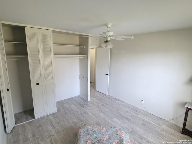 unfurnished bedroom with light hardwood / wood-style flooring, ceiling fan, and a closet