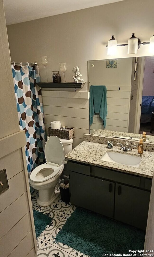 bathroom featuring vanity, tile patterned flooring, and toilet