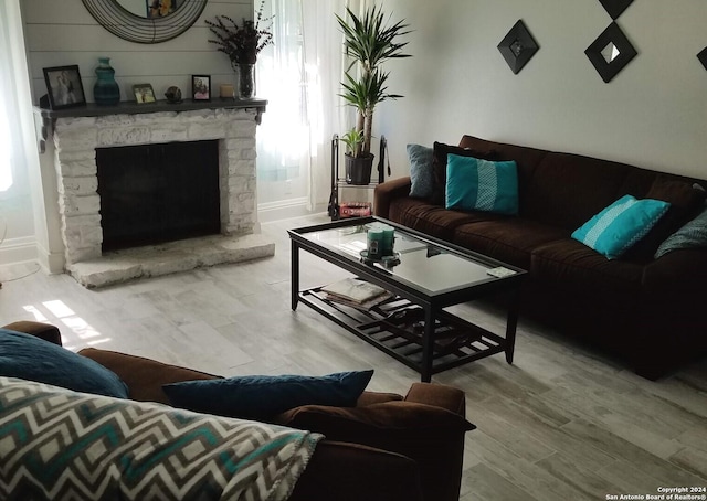 living room featuring plenty of natural light, a fireplace, and light wood-type flooring