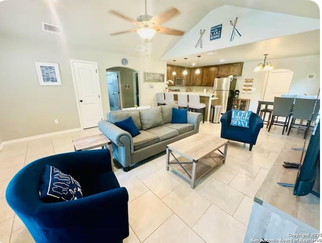 tiled living room featuring high vaulted ceiling and ceiling fan with notable chandelier