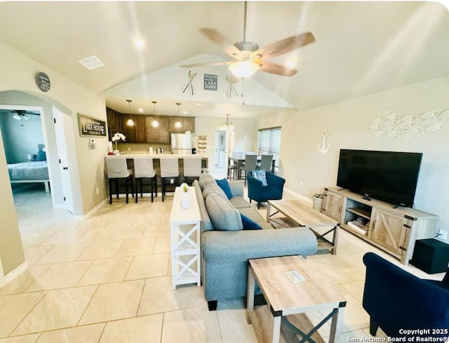 living room featuring lofted ceiling, light tile patterned floors, and ceiling fan