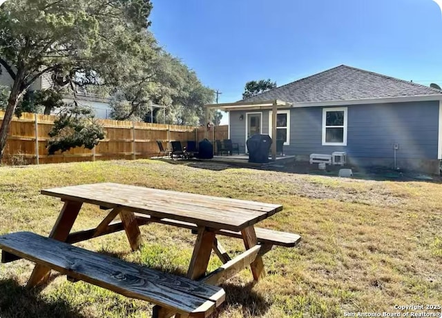 rear view of property featuring a patio and a yard