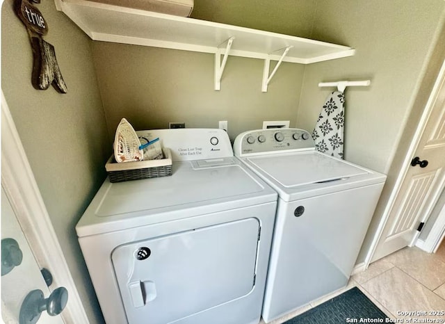 clothes washing area with washer and clothes dryer and light tile patterned floors