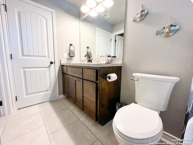 bathroom featuring vanity, toilet, and tile patterned flooring