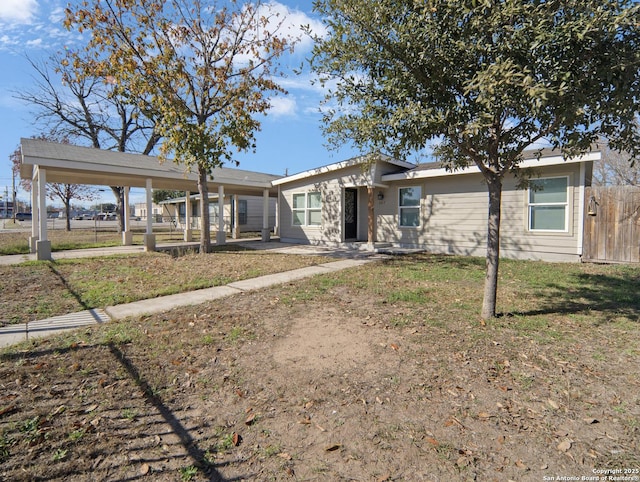 ranch-style house featuring a carport and a front lawn