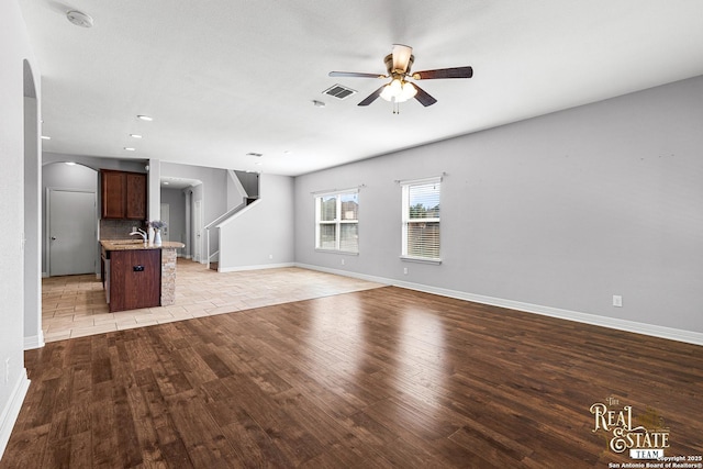 unfurnished living room with light hardwood / wood-style floors and ceiling fan