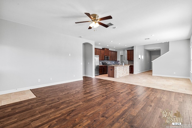 unfurnished living room featuring ceiling fan and light hardwood / wood-style floors