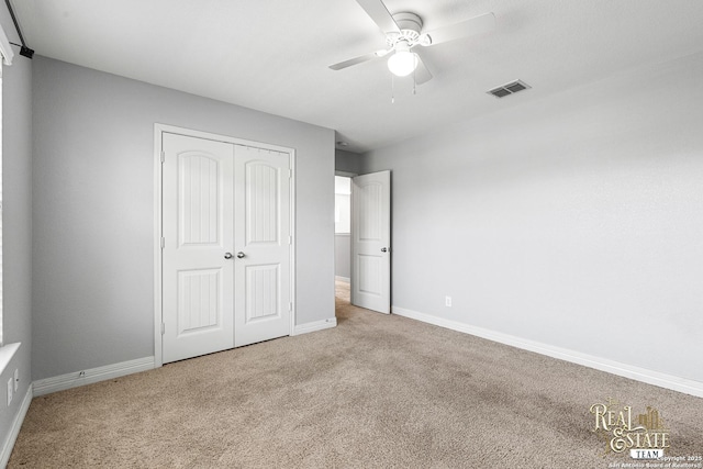 unfurnished bedroom featuring light carpet, a closet, and ceiling fan