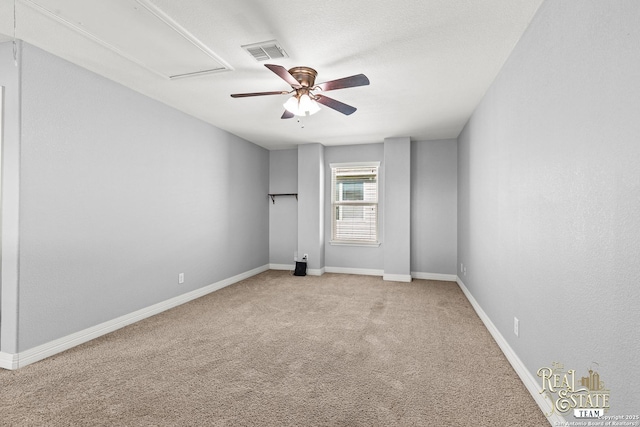 carpeted empty room with ceiling fan and a textured ceiling