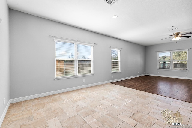 empty room featuring ceiling fan and plenty of natural light