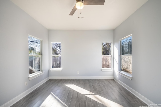 empty room with dark hardwood / wood-style flooring and ceiling fan