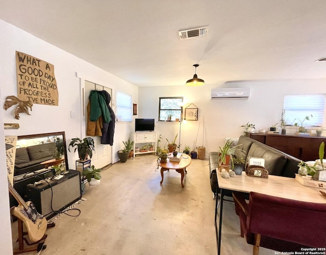 living room with concrete flooring and an AC wall unit