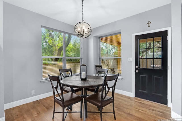 dining space with wood-type flooring and a chandelier