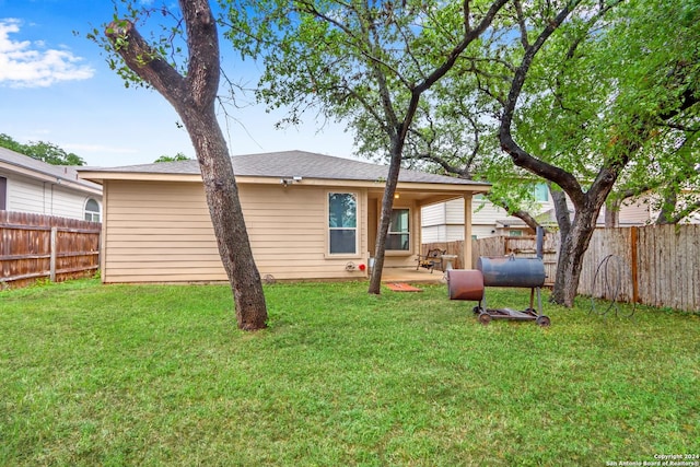 back of property with a patio area and a lawn