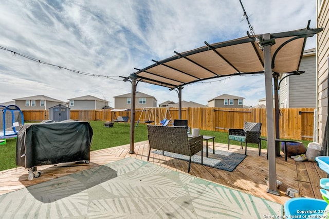 view of patio with a deck, a grill, a trampoline, and a pergola