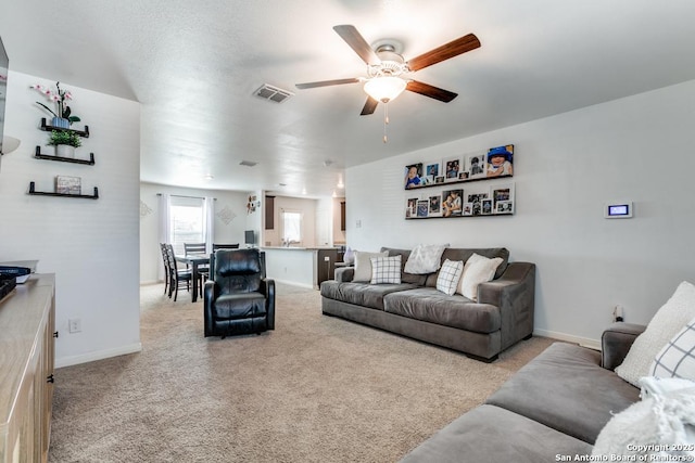 living room with light colored carpet and ceiling fan