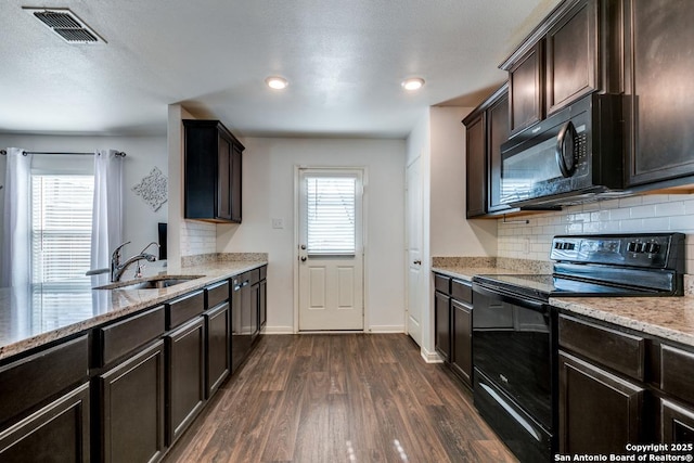 kitchen featuring dark hardwood / wood-style floors, sink, dark brown cabinetry, and black appliances