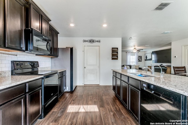 kitchen featuring sink, dark wood-type flooring, backsplash, and black appliances