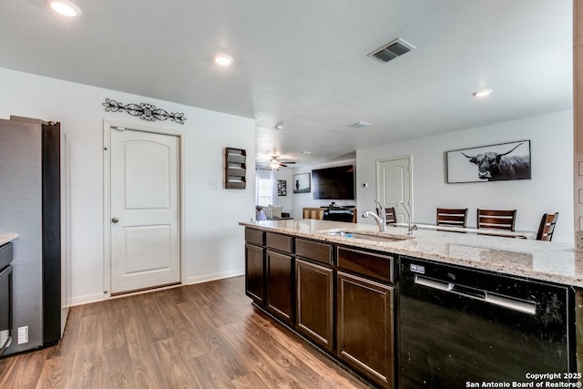 kitchen with sink, stainless steel fridge, dishwasher, dark hardwood / wood-style floors, and light stone countertops