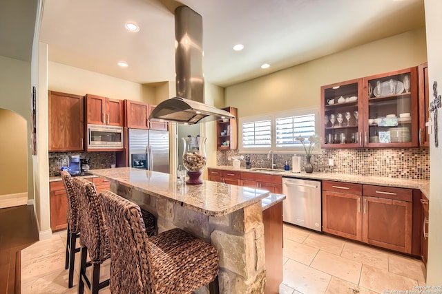 kitchen featuring a center island, stainless steel appliances, a kitchen breakfast bar, and island exhaust hood