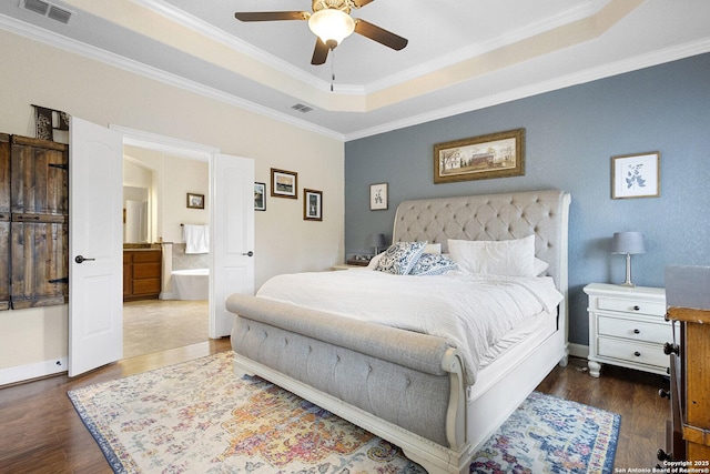 bedroom featuring a tray ceiling, dark wood-type flooring, and ornamental molding