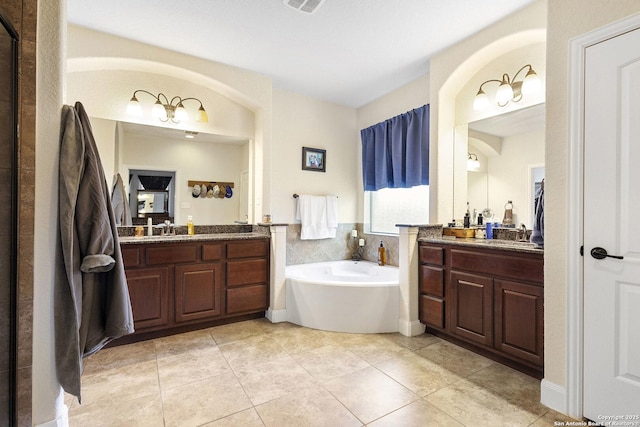 bathroom featuring vanity, tile patterned floors, and a tub