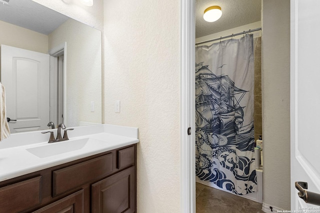 bathroom featuring vanity, curtained shower, tile patterned floors, and a textured ceiling