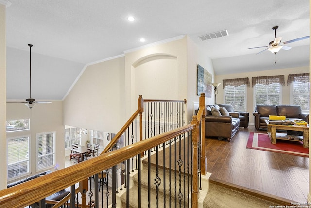 corridor with crown molding, hardwood / wood-style flooring, and vaulted ceiling