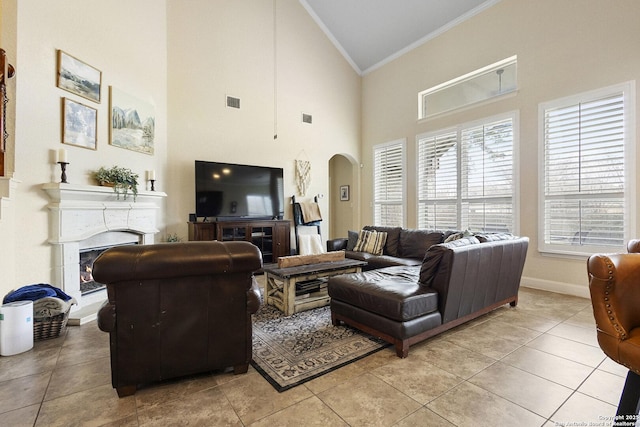 tiled living room with crown molding and high vaulted ceiling