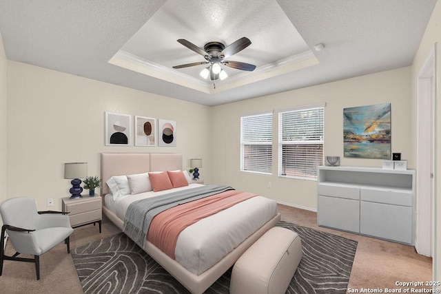 carpeted bedroom with a raised ceiling, ornamental molding, and a textured ceiling