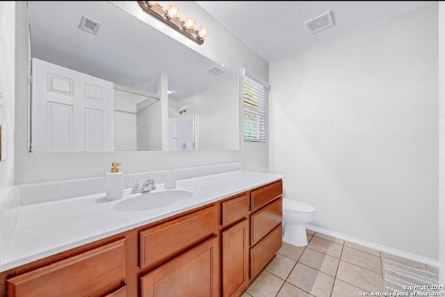 bathroom featuring tile patterned flooring, vanity, a textured ceiling, toilet, and walk in shower