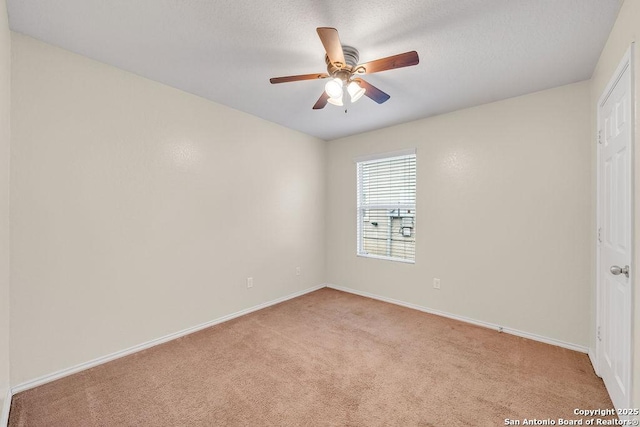 carpeted spare room featuring a textured ceiling and ceiling fan