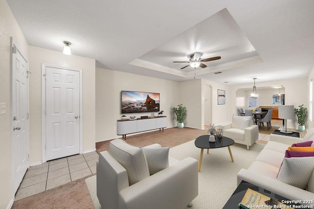 tiled living room with ceiling fan, a raised ceiling, and a textured ceiling